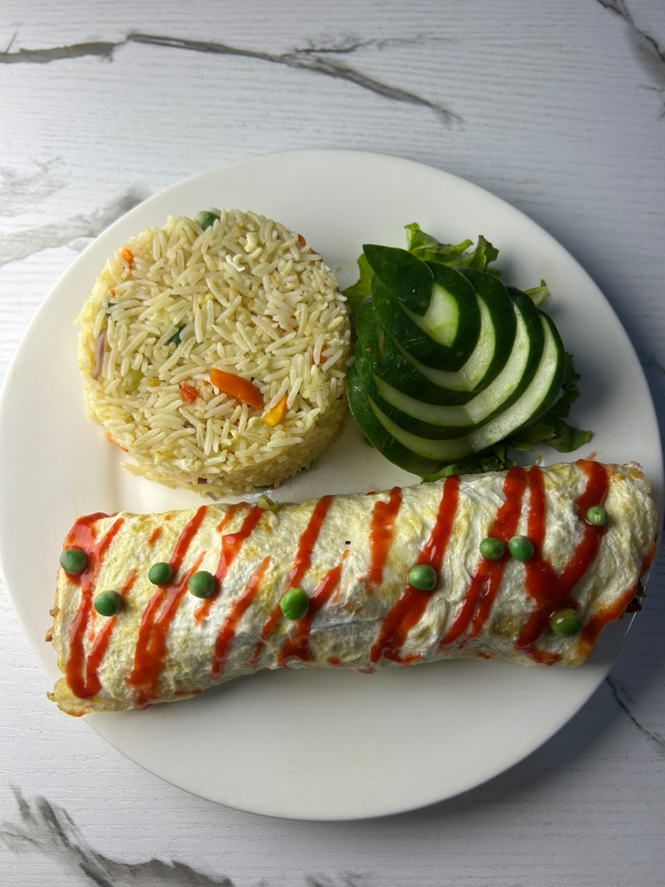 Fried rice with a rolled omelette and fresh cucumber